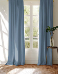 Amara Ocean blue curtains covering a window looking into the garden