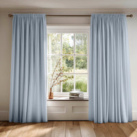 Bespoke pencil pleat curtains in light blue cotton fabric. Country setting.