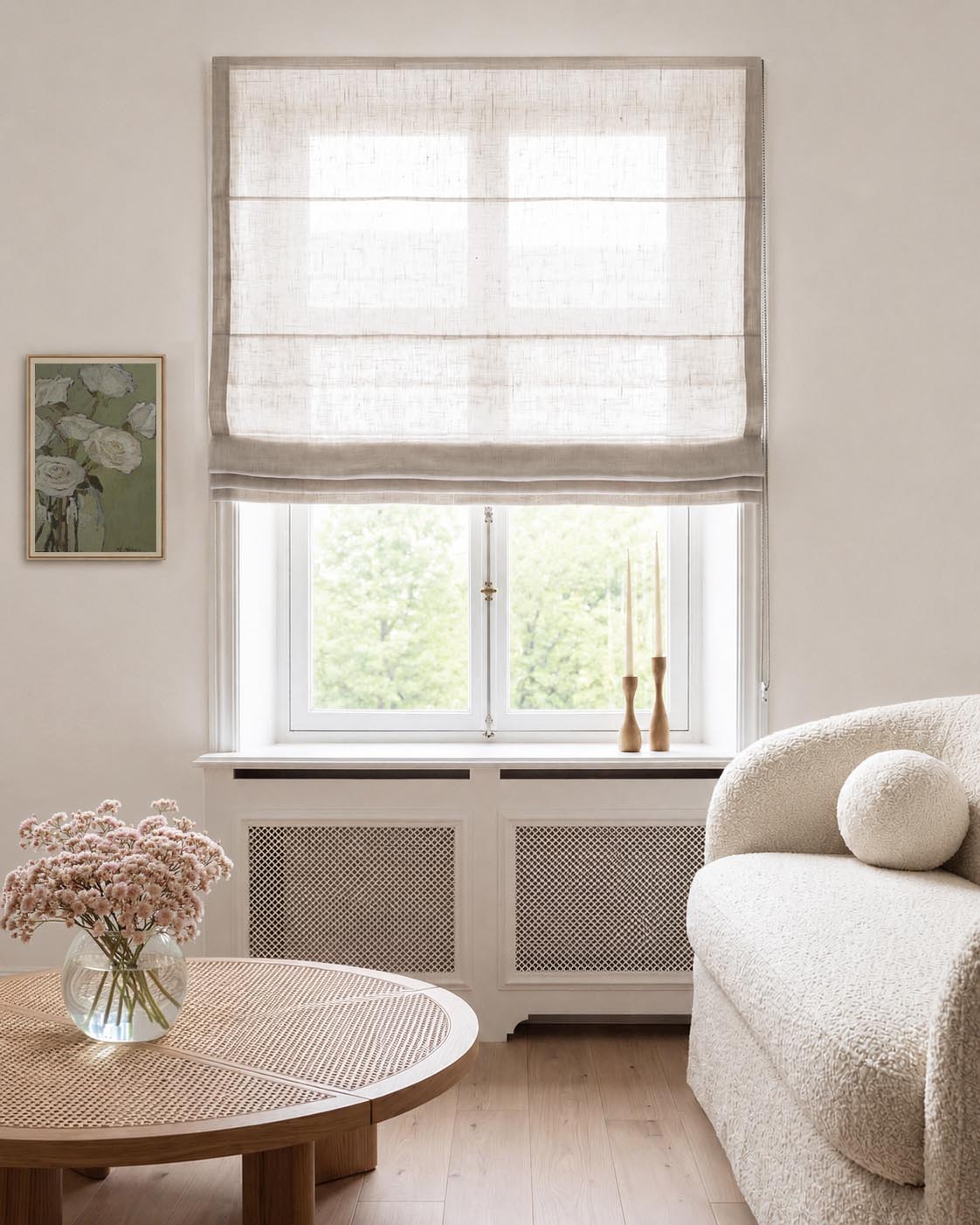 A light beige linen Roman blind with horizontal pleats.