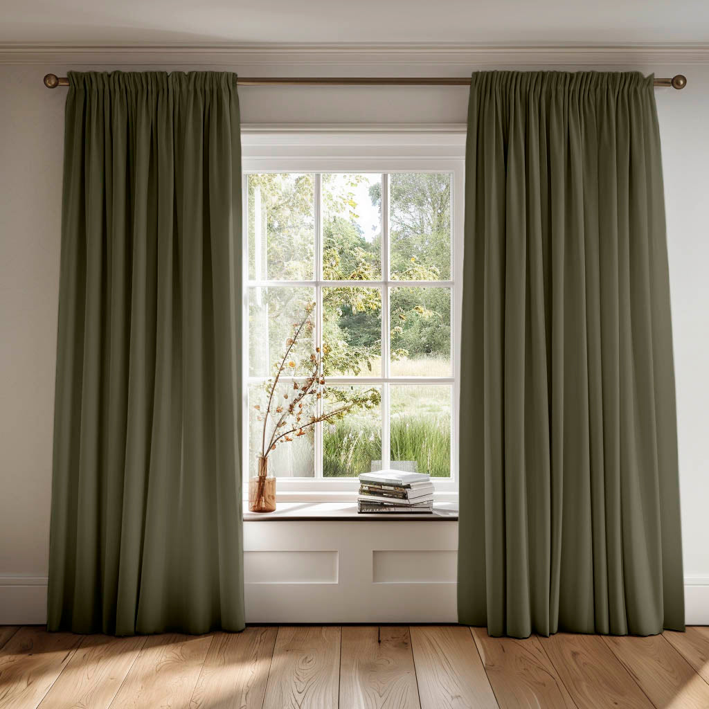 Pair of green curtains covering a window looking into trees outside