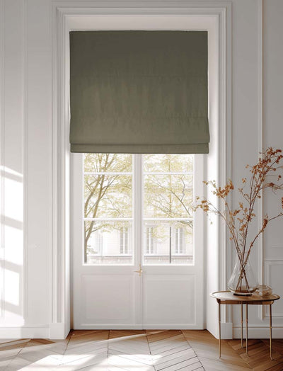 Green roman blind covering a window facing a building across the street
