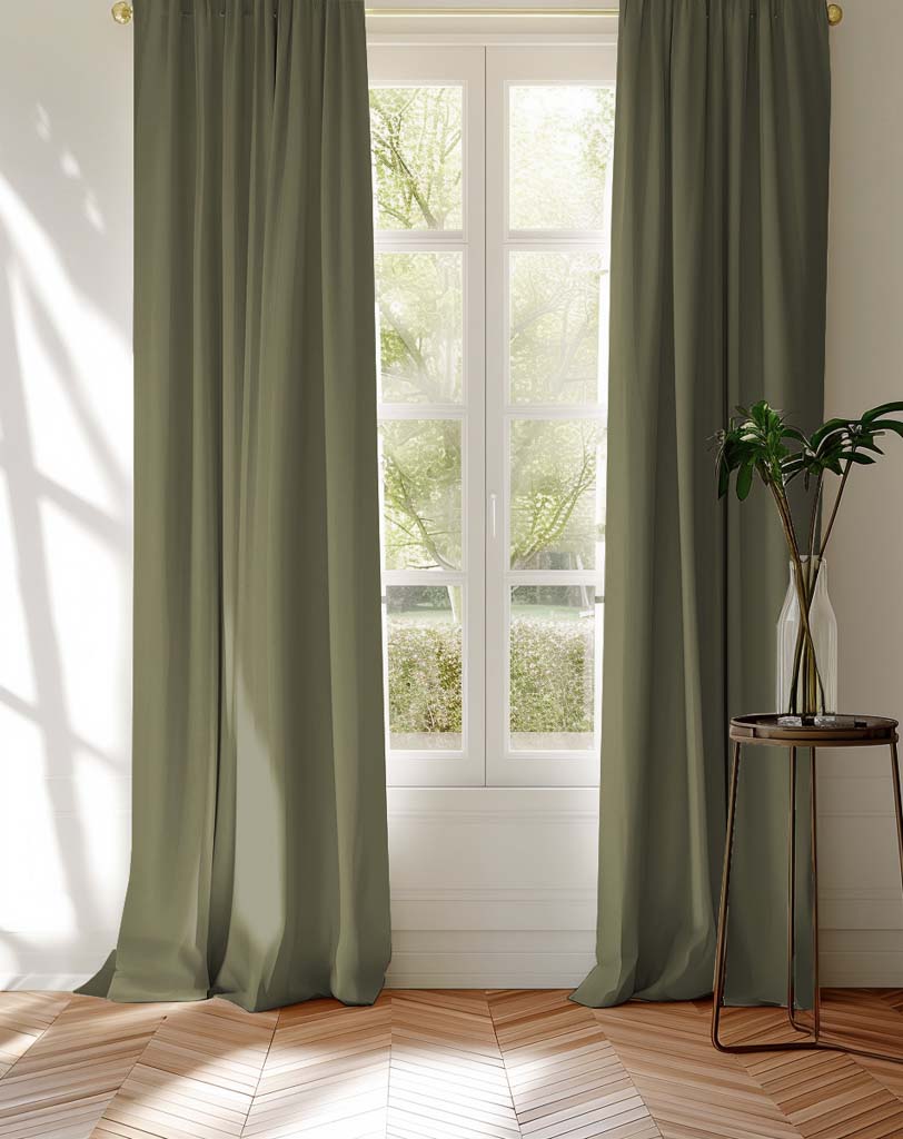 Pair of green curtains covering a window looking into garden