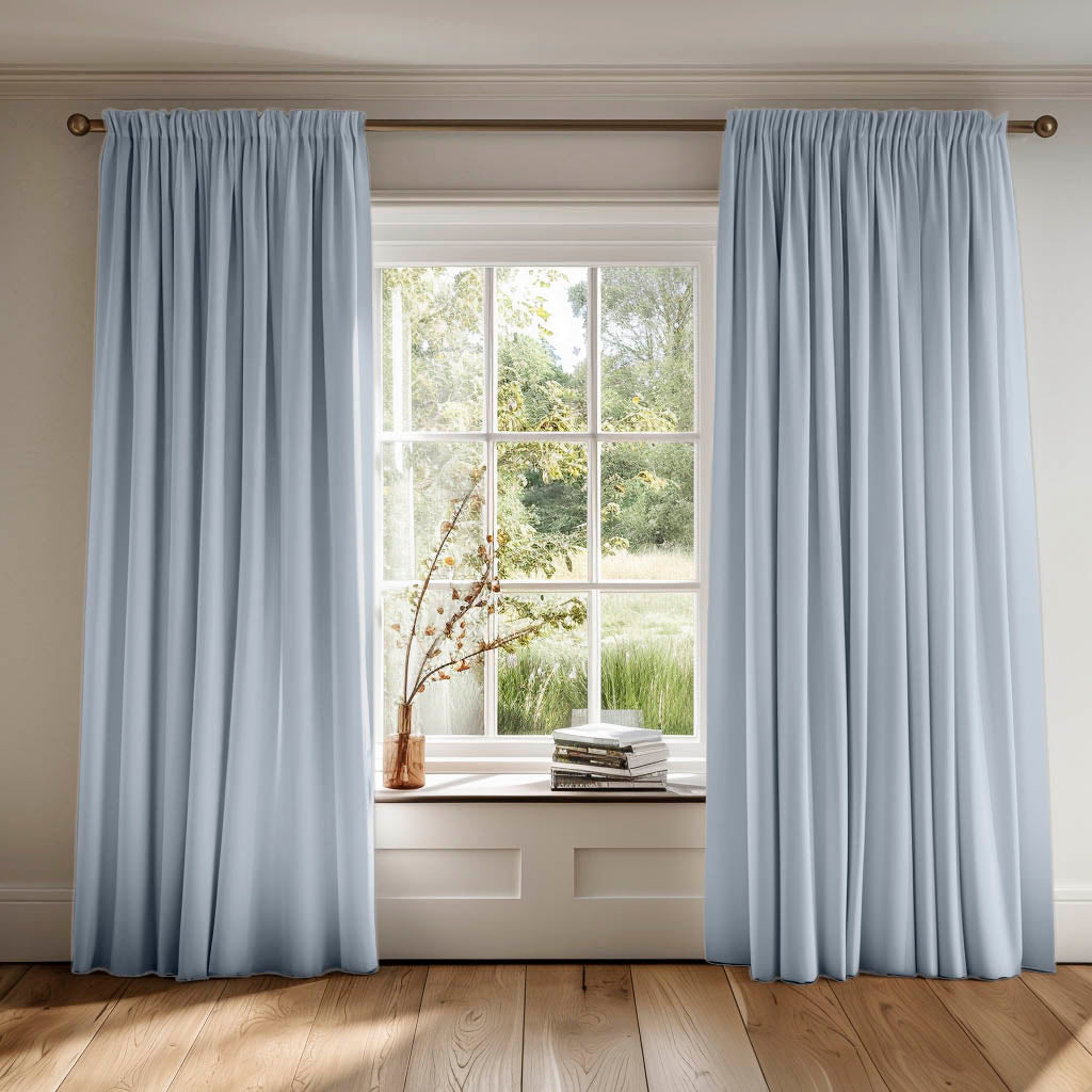 Bespoke pencil pleat curtains in light blue cotton fabric. Country setting.