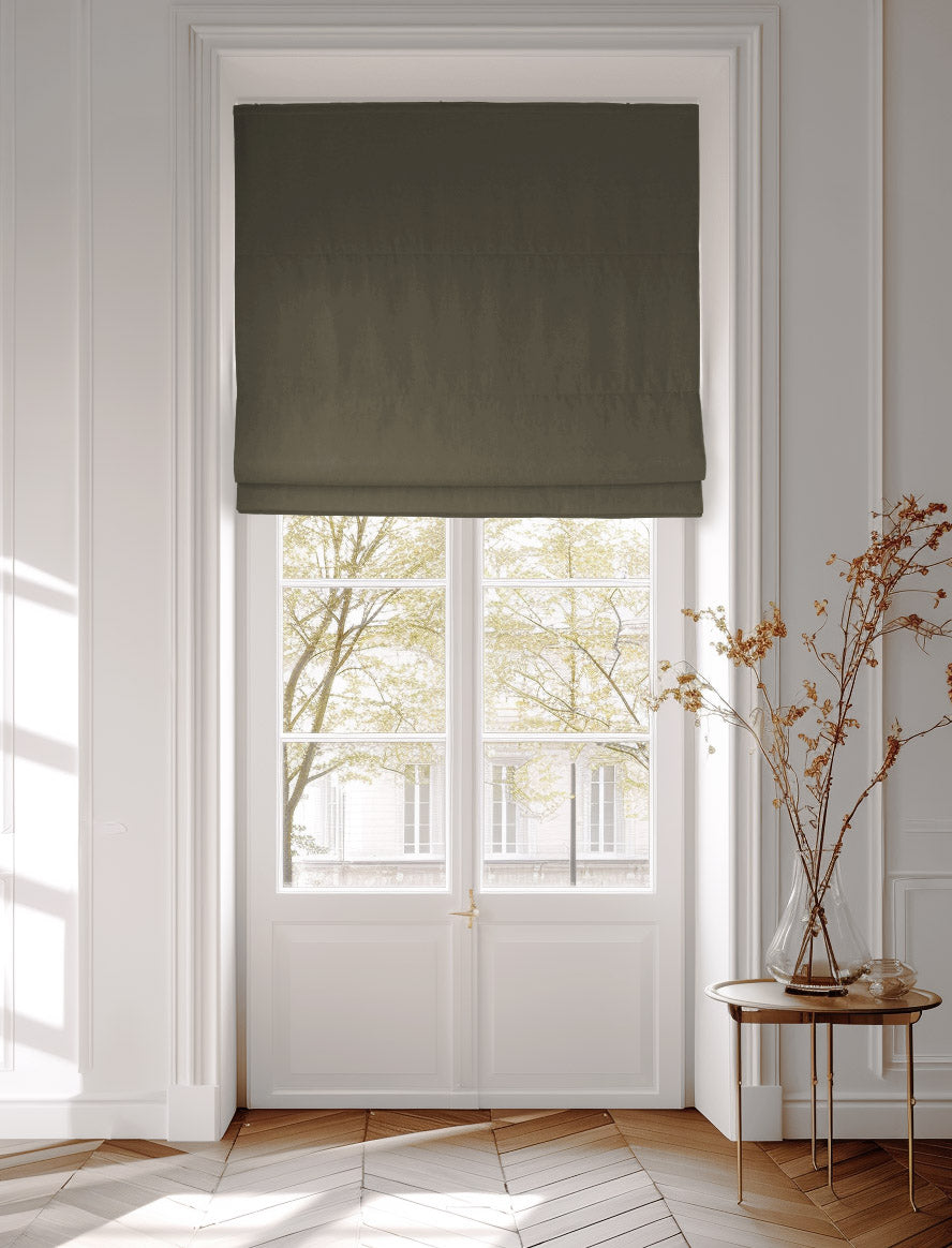 Window decorated with a dark green roman blind in cotton